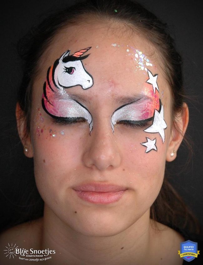 a girl with outlined unicorn face paint and white gradient eye shadow