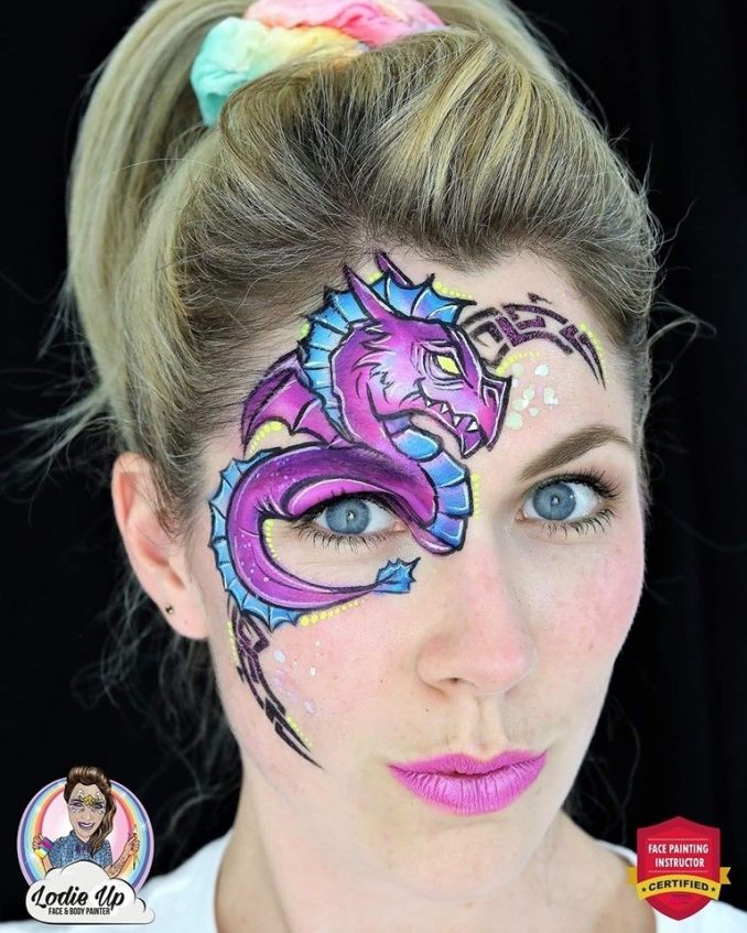 a woman with a purple dragon face paint desing