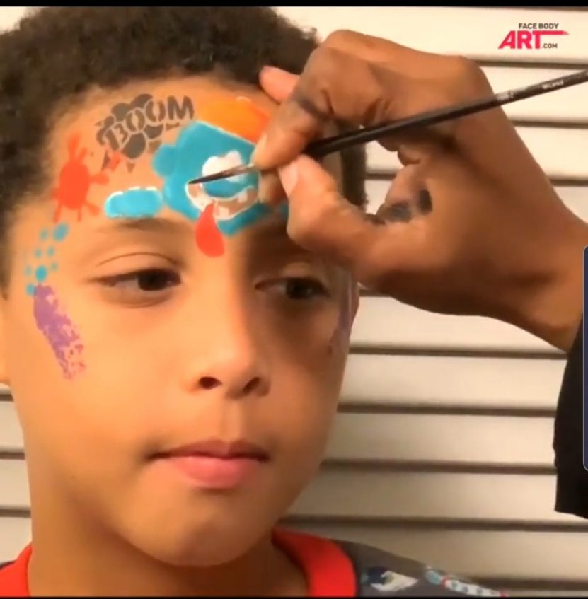 a boy having his face painted